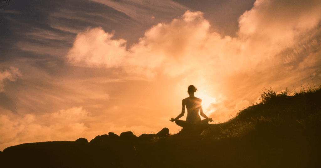 An image showing a person meditating in the nature